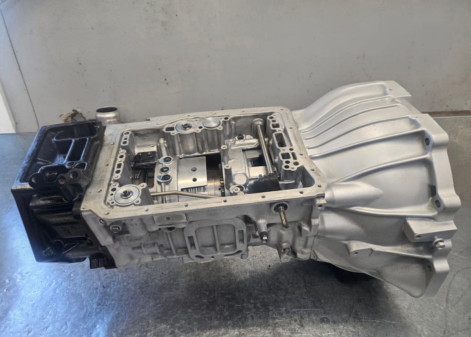 Automatic transmission with the sump removed, exposing the valve body and gear train on the workbench